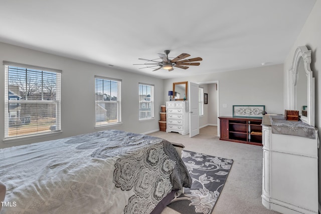 bedroom featuring a ceiling fan, light carpet, and baseboards