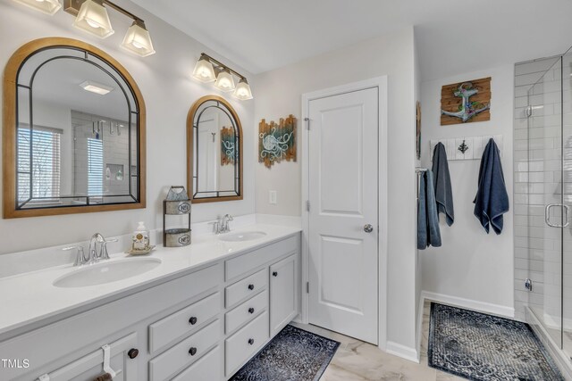 bathroom featuring double vanity, a stall shower, marble finish floor, and a sink