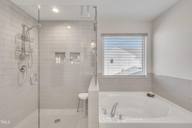 bathroom featuring a stall shower and a bath