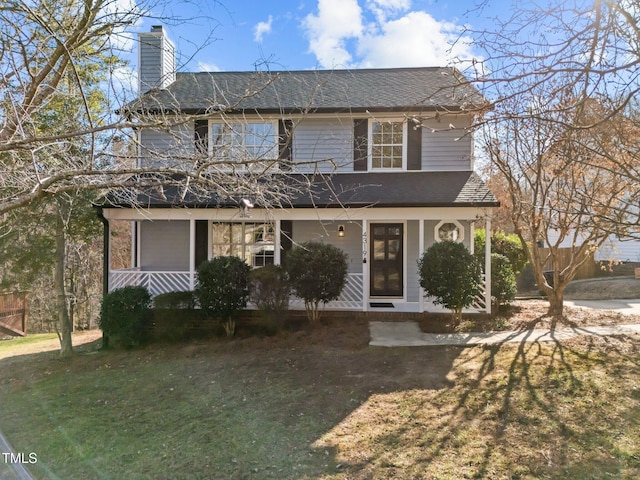 view of front facade featuring a chimney, a front lawn, and a porch