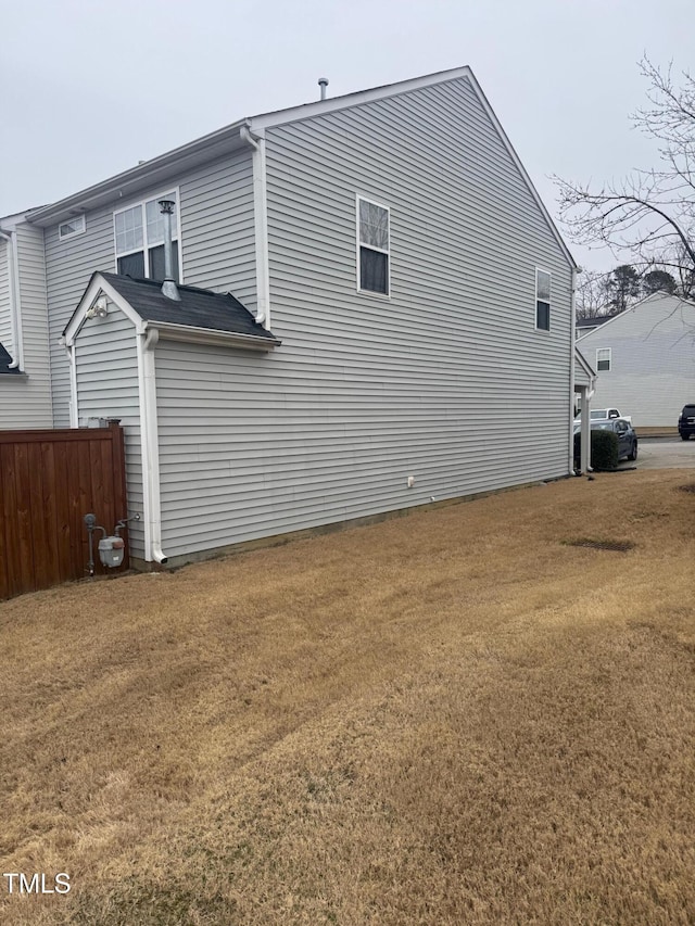 view of side of property with a yard and fence