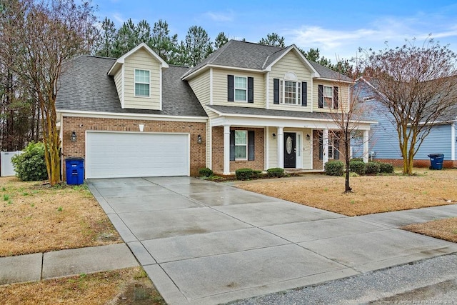 view of front of house featuring brick siding, driveway, an attached garage, and roof with shingles