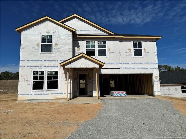 property in mid-construction featuring gravel driveway and an attached garage