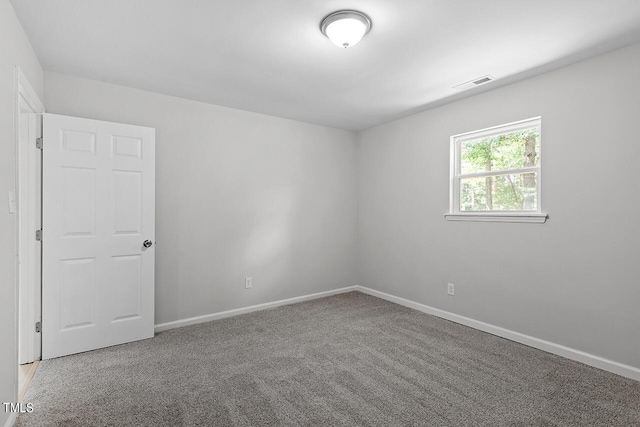 carpeted empty room with visible vents and baseboards