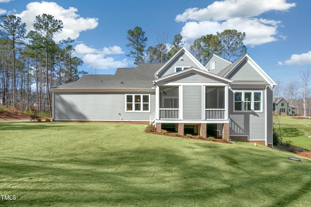 rear view of property featuring a sunroom and a yard