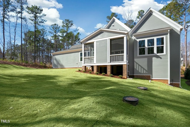 back of house with a sunroom and a lawn