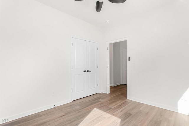 spare room featuring ceiling fan, light wood-type flooring, and baseboards