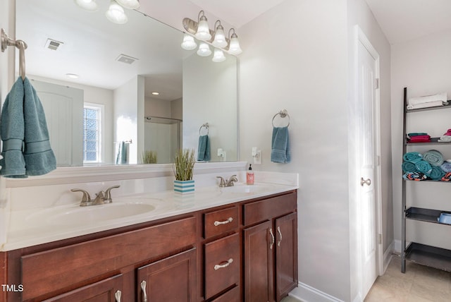 bathroom with double vanity, visible vents, and a sink