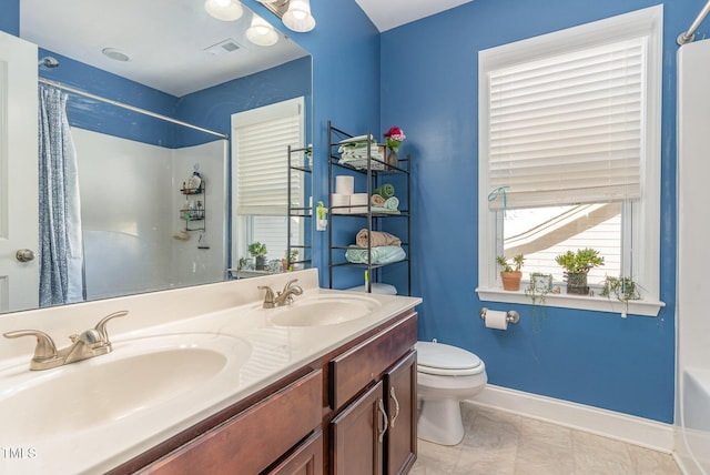 bathroom featuring baseboards, a sink, toilet, and double vanity