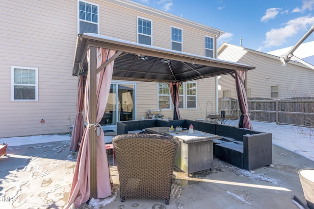 view of patio / terrace featuring an outdoor living space with a fire pit, fence, and a gazebo