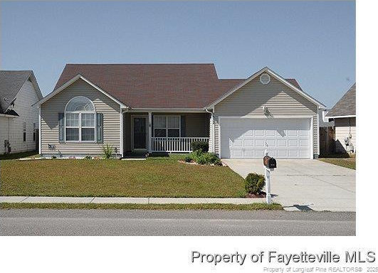 single story home featuring covered porch, driveway, a front lawn, and an attached garage