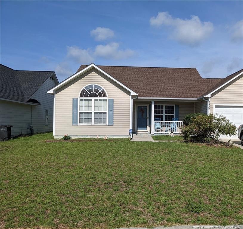 single story home featuring a garage, covered porch, and a front lawn