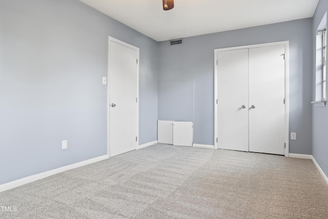 unfurnished bedroom with baseboards, visible vents, a ceiling fan, carpet floors, and a closet