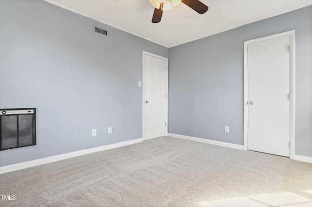 spare room featuring a ceiling fan, carpet, visible vents, and baseboards