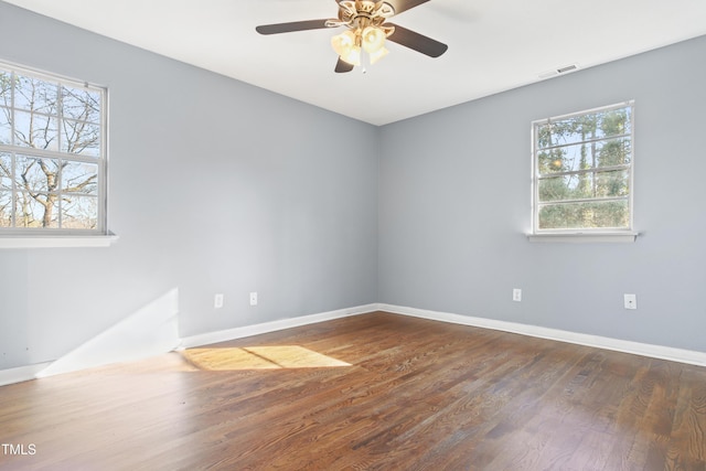 unfurnished room featuring ceiling fan, wood finished floors, visible vents, and baseboards