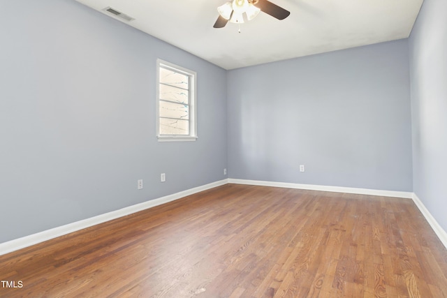 unfurnished room featuring light wood-style flooring, a ceiling fan, visible vents, and baseboards