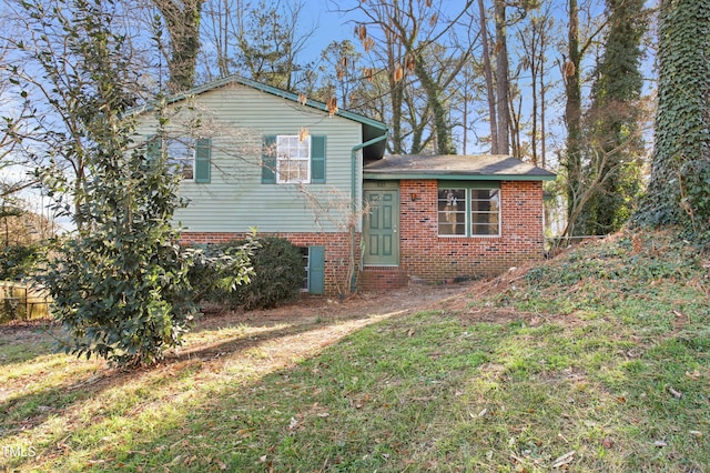 view of front of property with brick siding, a front yard, and fence