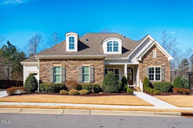 view of front of house with stone siding and roof with shingles