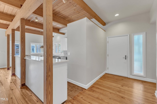 entryway featuring light wood finished floors, wood ceiling, baseboards, and beam ceiling