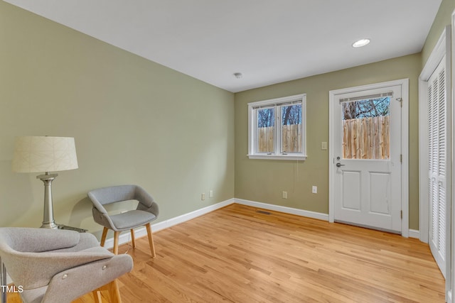 sitting room with light wood finished floors, recessed lighting, and baseboards