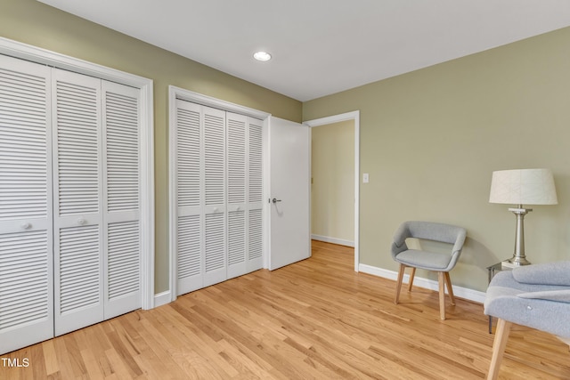 living area featuring recessed lighting, light wood-type flooring, and baseboards