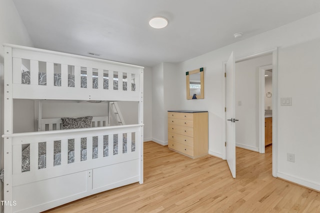 bedroom with light wood-type flooring, visible vents, and baseboards