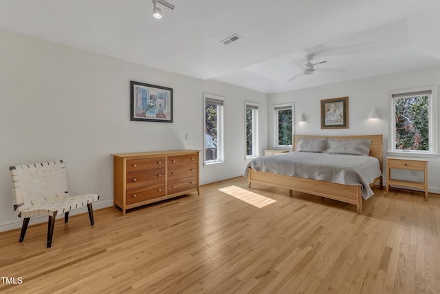 bedroom with a ceiling fan, baseboards, visible vents, and light wood finished floors