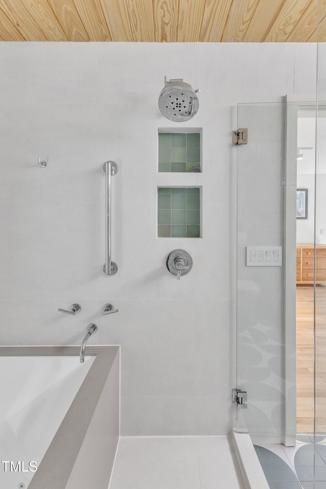 bathroom with walk in shower and a bath