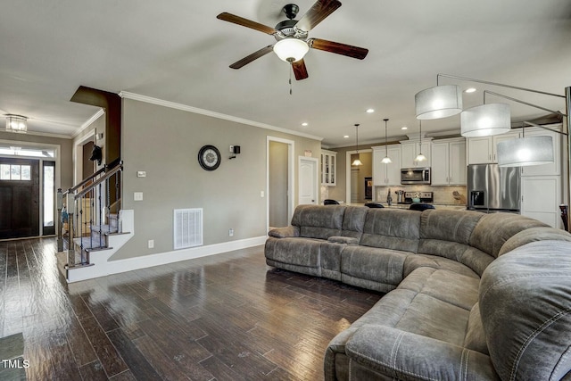 living area featuring dark wood-type flooring, stairway, visible vents, and baseboards