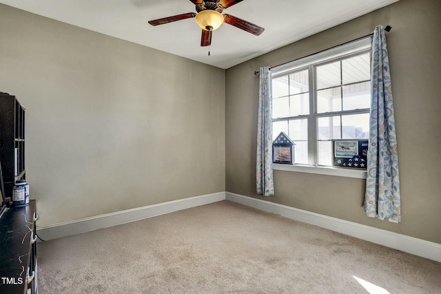 empty room featuring carpet, baseboards, and ceiling fan