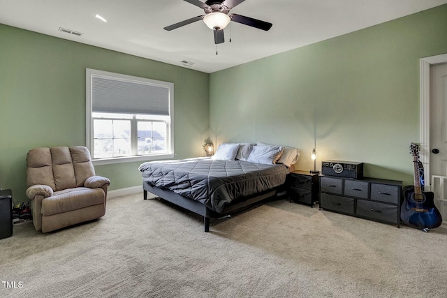 bedroom with light carpet, ceiling fan, visible vents, and baseboards