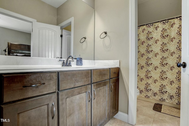 full bath with baseboards, vanity, and tile patterned floors