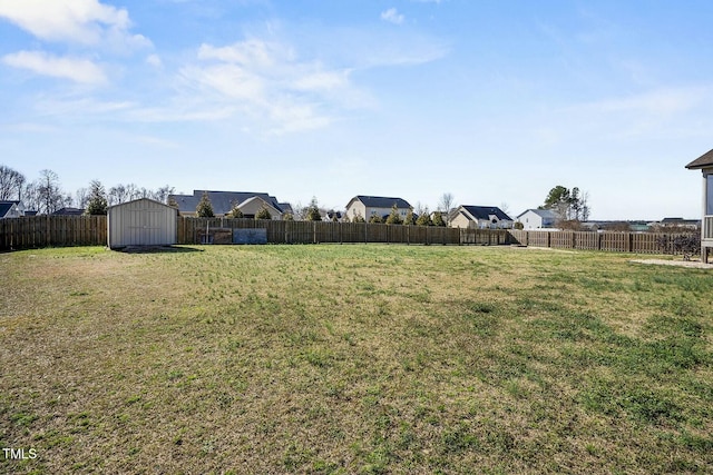 view of yard with an outbuilding, a shed, and a fenced backyard