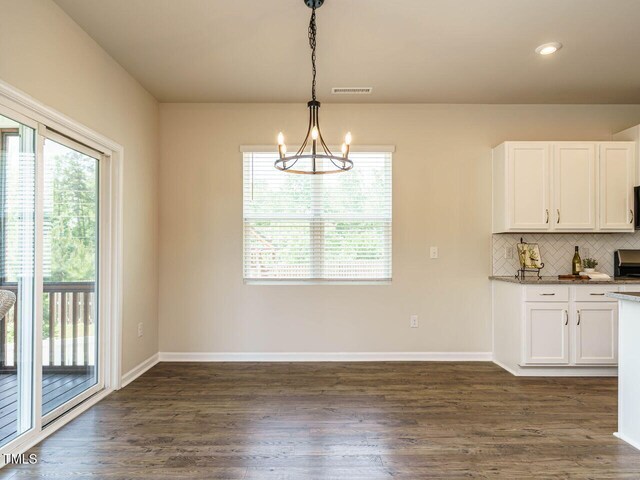 kitchen featuring plenty of natural light, a chandelier, white cabinets, decorative backsplash, and recessed lighting