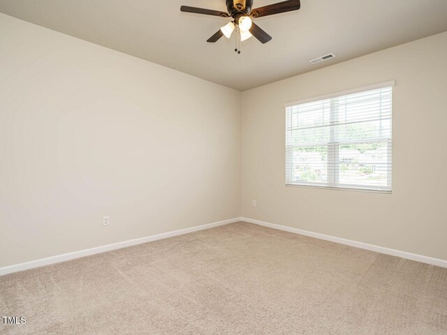 carpeted empty room featuring baseboards and a ceiling fan