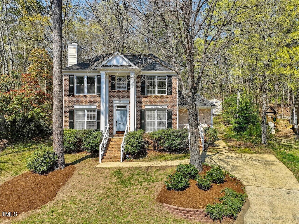 4818 Glendarion Dr, Durham, NC 27713 - neoclassical home with brick siding, a chimney, and a front yard