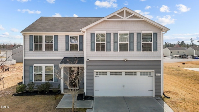 view of front of property featuring a front lawn, an attached garage, and driveway