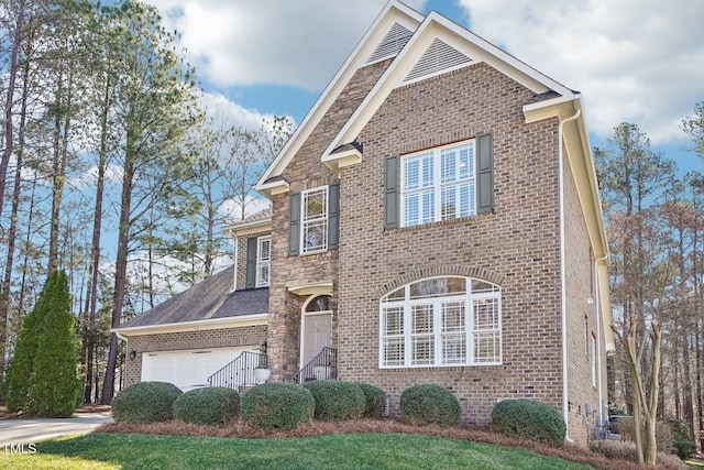 traditional-style home with stone siding, brick siding, and an attached garage