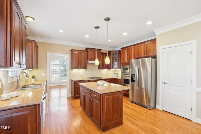 kitchen with a sink, stainless steel appliances, under cabinet range hood, and light wood-style flooring