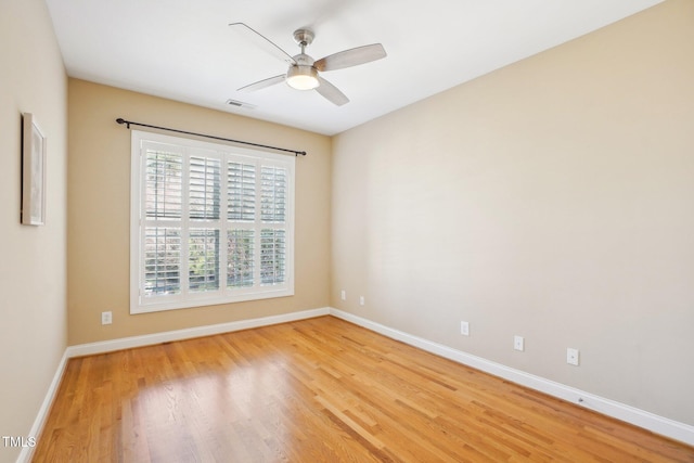 empty room with baseboards, visible vents, light wood finished floors, and ceiling fan