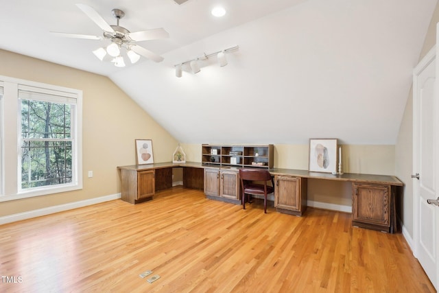 unfurnished office with track lighting, baseboards, ceiling fan, lofted ceiling, and light wood-style flooring