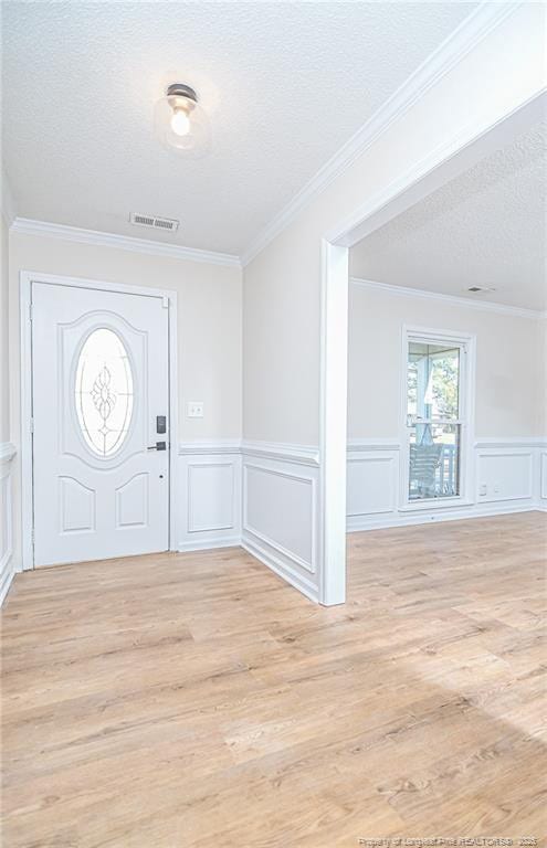 foyer with visible vents, light wood-style flooring, and a textured ceiling