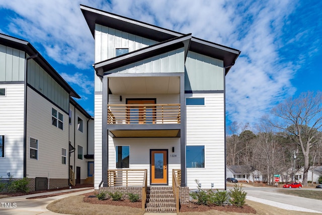 modern home featuring board and batten siding and a balcony