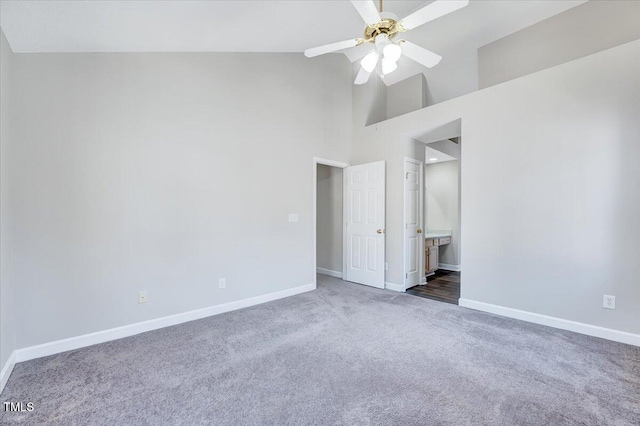 unfurnished bedroom with carpet floors, connected bathroom, ceiling fan, high vaulted ceiling, and baseboards