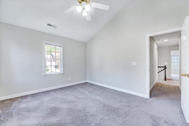 spare room with a healthy amount of sunlight, visible vents, vaulted ceiling, and baseboards