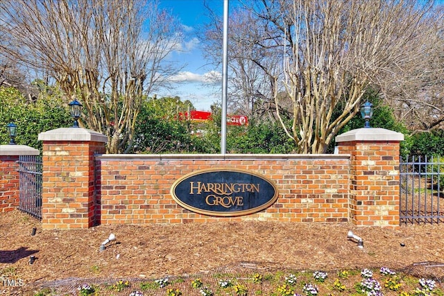 community / neighborhood sign featuring fence