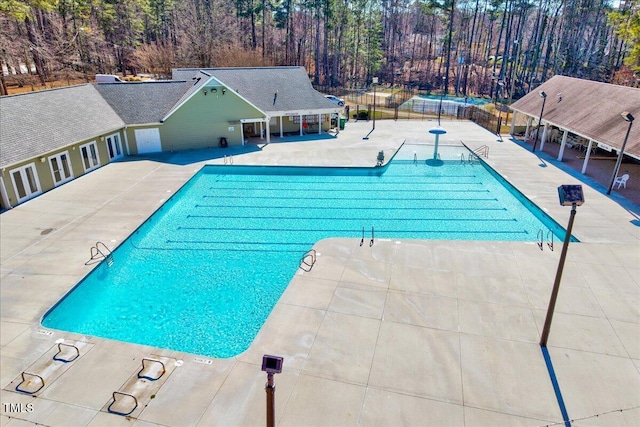 community pool with fence and a patio