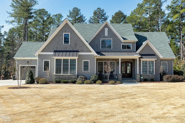 craftsman-style home featuring a garage, roof with shingles, a standing seam roof, covered porch, and french doors