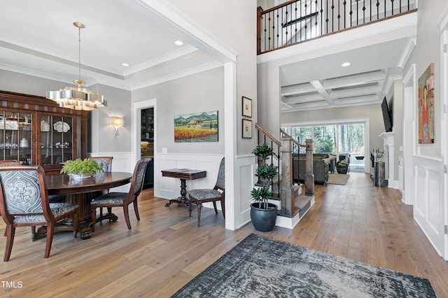 dining area with beamed ceiling, coffered ceiling, hardwood / wood-style flooring, and a notable chandelier