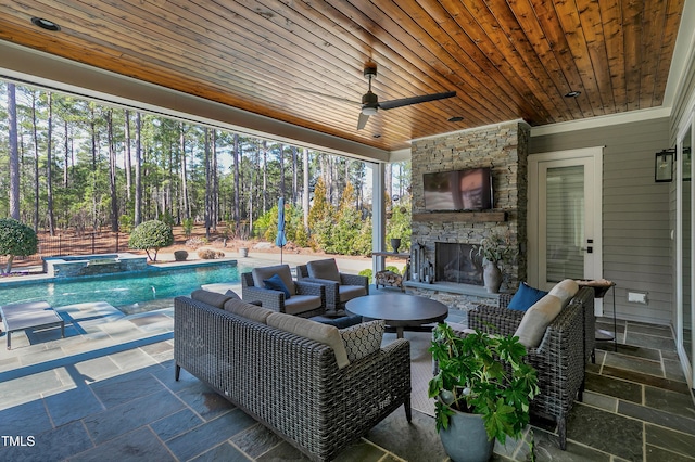 view of patio with a pool with connected hot tub, ceiling fan, and an outdoor living space with a fireplace